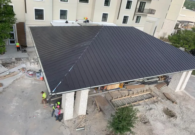 Metal roofing installation team working on a commercial building in Hilltown